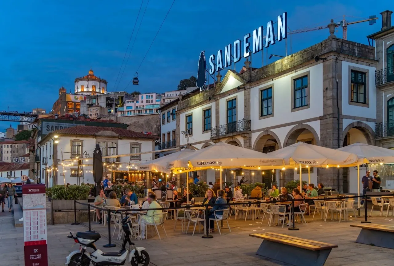 Terrazas junto a las bodegas del muelle de Vila Nova de Gaia al anochecer