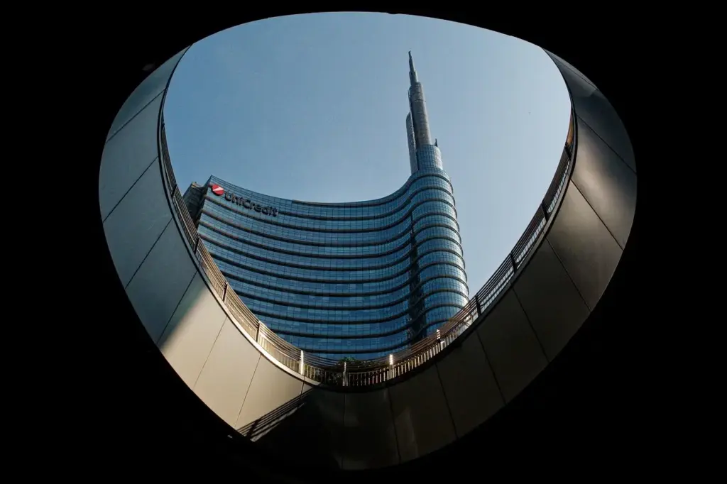 Torre UniCredit de cristal y su aguja vista desde una estructura curva en Porta Nuova, Milán